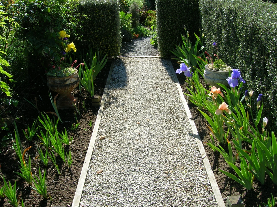 A gravel garden path edged in timber and plants